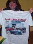 Highlight for Album: Cindy holds up the 2009 Derrick Ward Memorial car show T-shirt as we plan for the 2010 show.